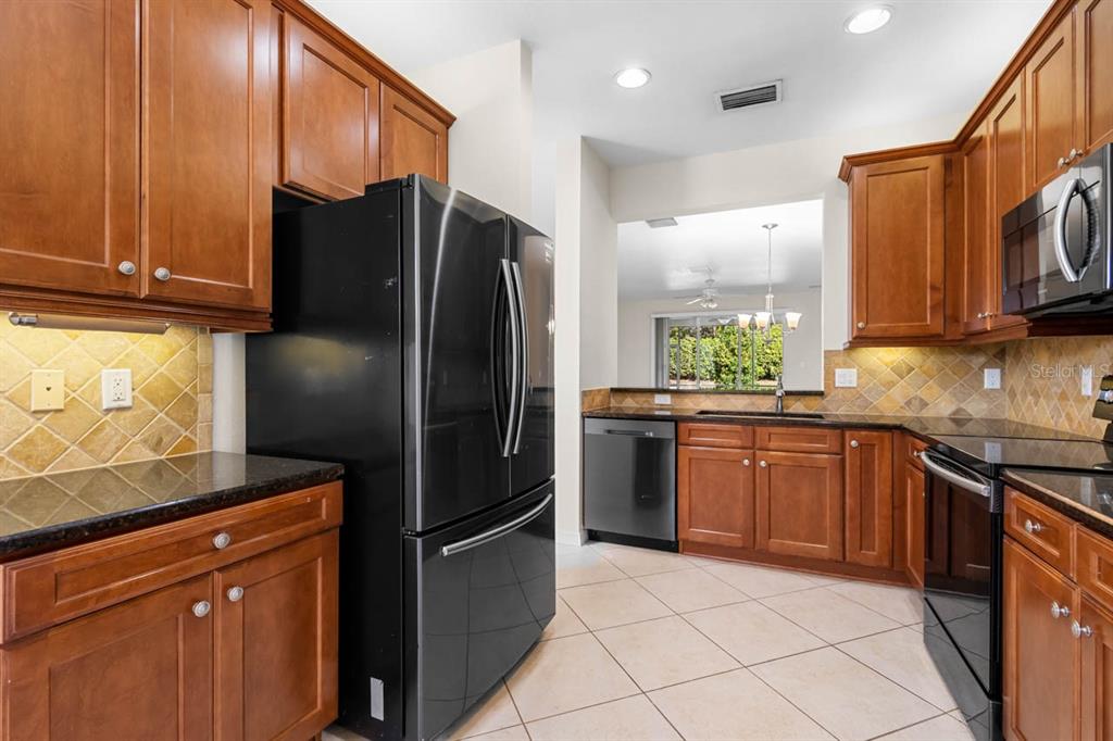 16252 Amethyst Key Drive Wimauma, FL 33598 - Photo 15 of 47 a kitchen with stainless steel appliances granite countertop a refrigerator sink and microwave