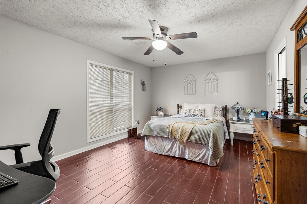 4420 Hudson Mill Road Cataula, GA 31804 - Photo 15 of 25 a spacious bedroom with a bed a chandelier and a window