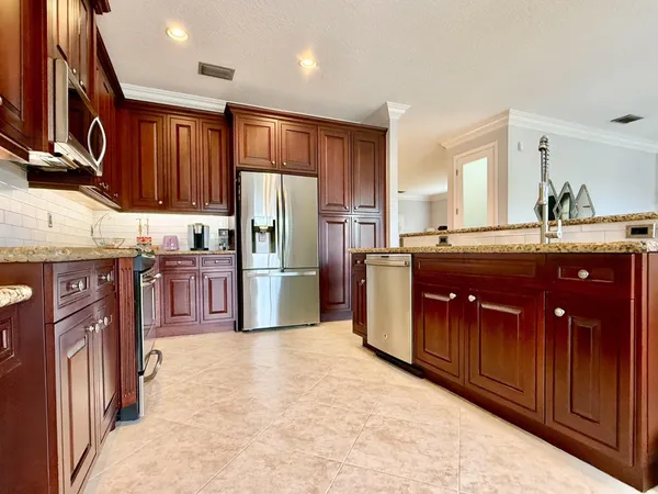 a kitchen with a sink a refrigerator and a wooden cabinets