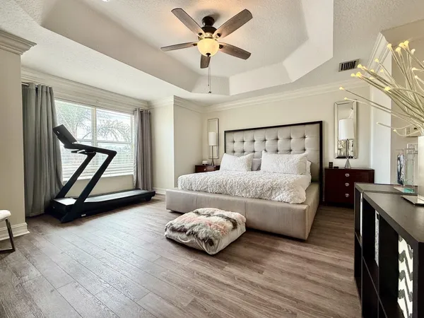 a bedroom with a bed and a potted plant with the dresser