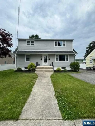 a front view of a house with a garden and yard