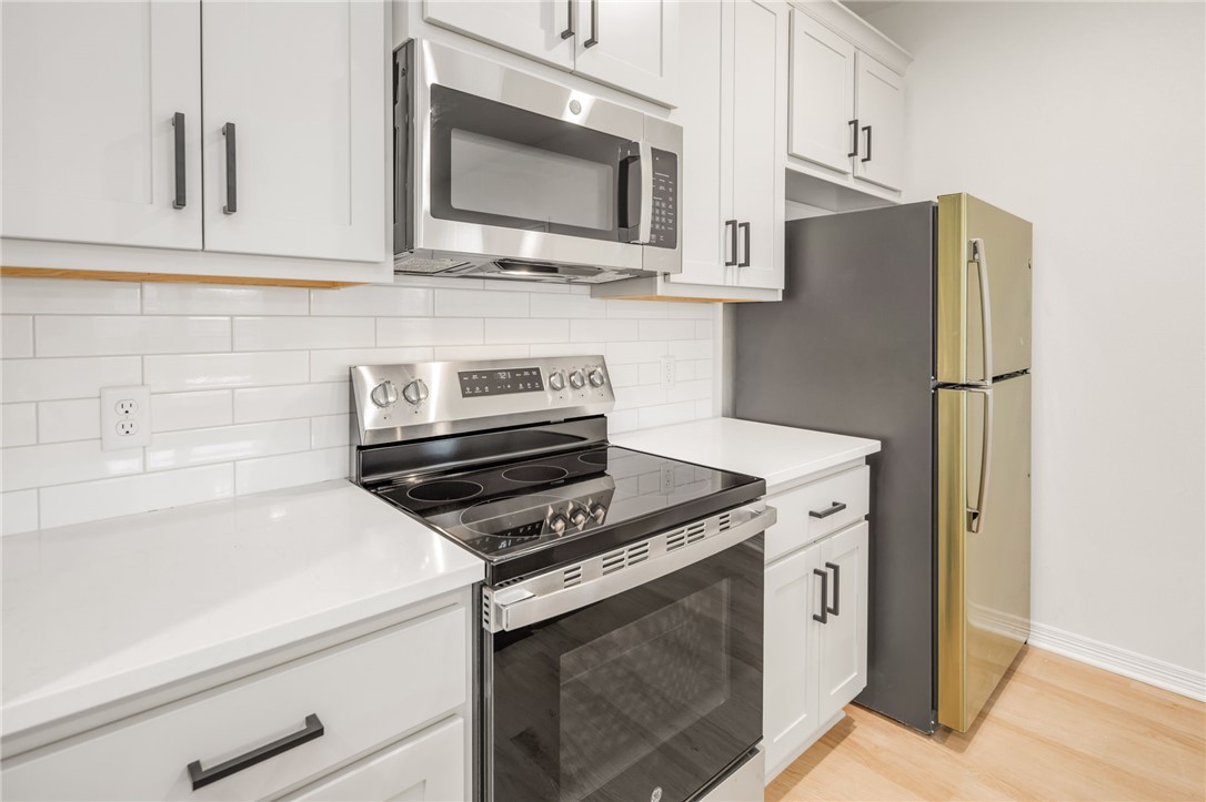 412 Ash Street College Station, TX 77840 - Photo 11 of 21 a kitchen with stainless steel appliances white cabinets and a stove top oven