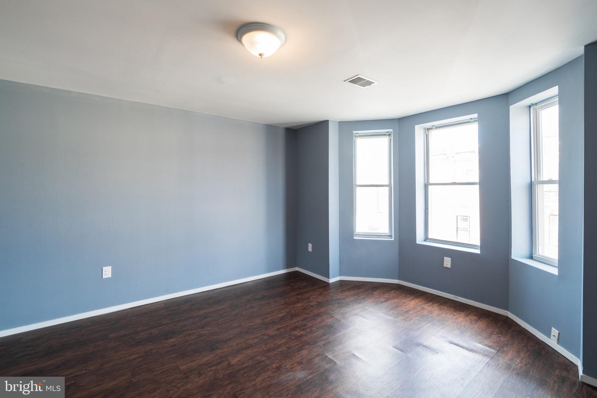 1833 South 22nd Street, Unit 2 Philadelphia, PA 19145 - Photo 8 of 15 an empty room with wooden floor and windows