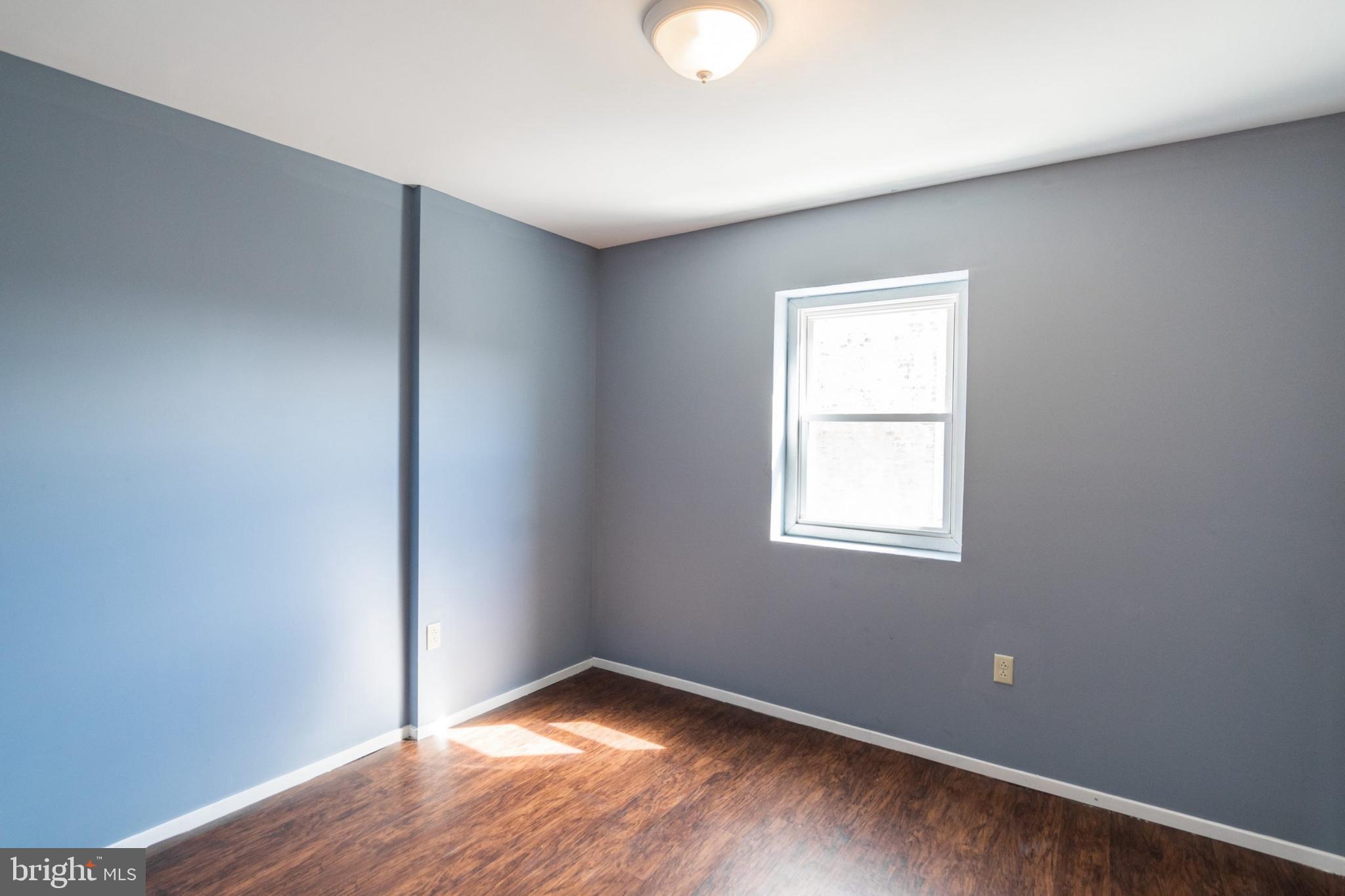 1833 South 22nd Street, Unit 2 Philadelphia, PA 19145 - Photo 9 of 15 an empty room with wooden floor and windows