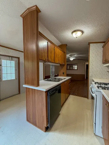a kitchen with stainless steel appliances granite countertop a stove refrigerator sink and cabinets