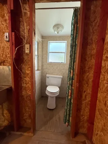 a view of an empty room with a fireplace and a window