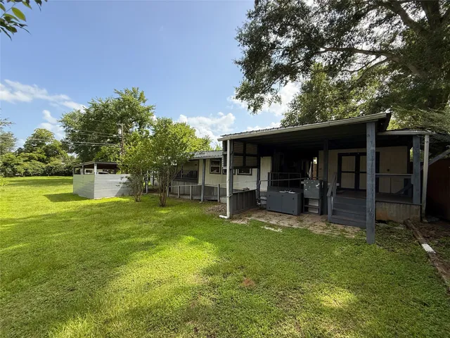 a view of a house with backyard porch and sitting area