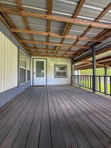 a view of a backyard with wooden fence and a large tree