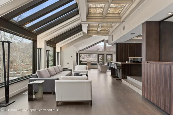 a living room with furniture a flat screen tv and a floor to ceiling window