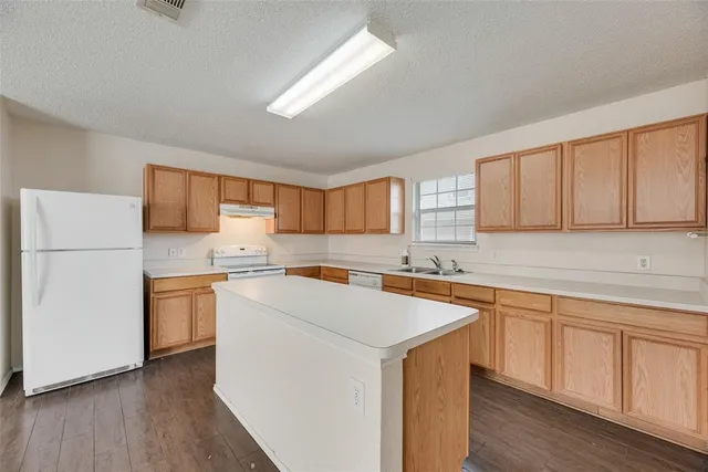 a view of a kitchen with a sink cabinets and wooden floor