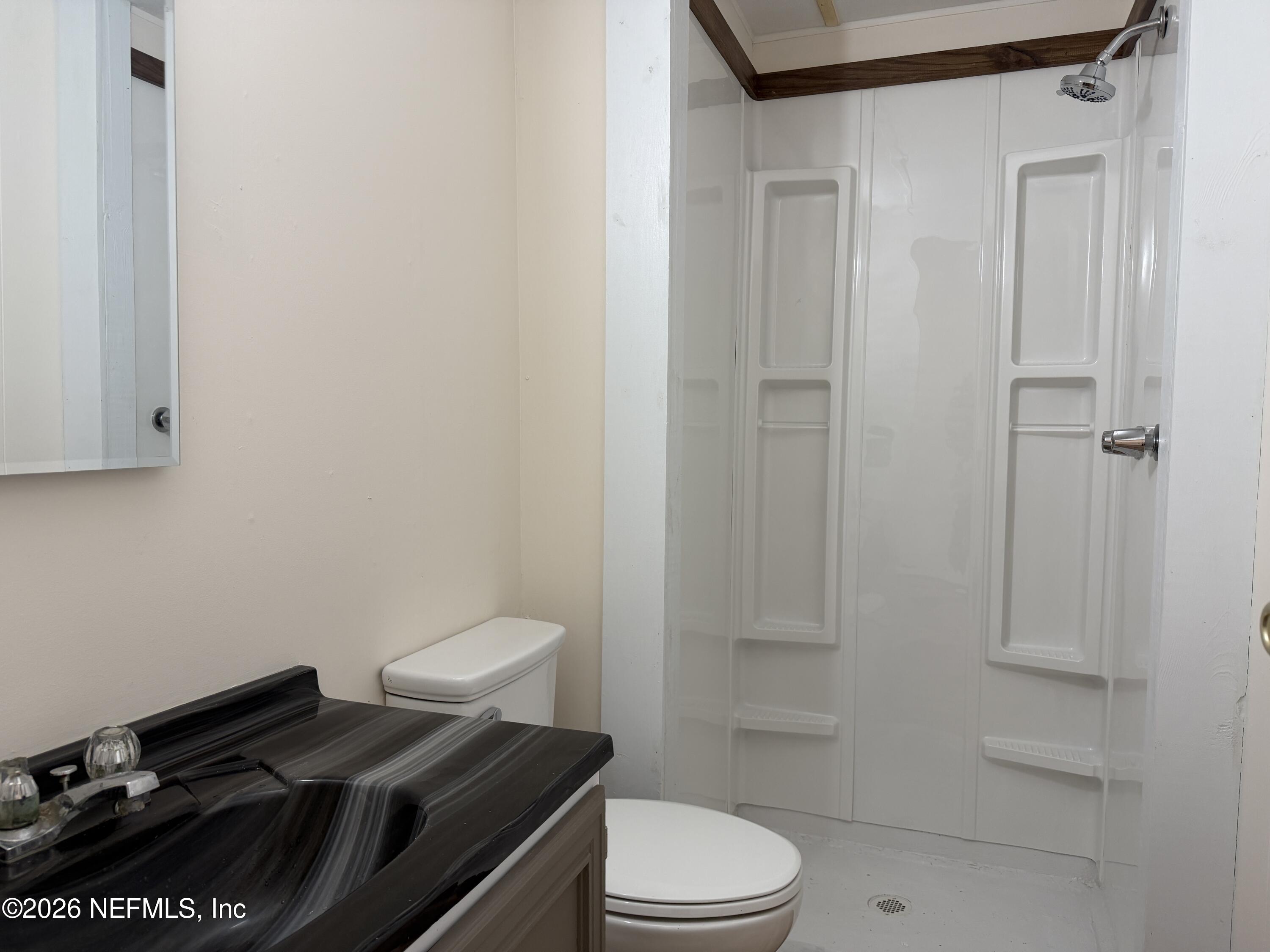 110 Kitty Lane Interlachen, FL 32148 - Photo 12 of 14 a bathroom with a granite countertop toilet and a shower