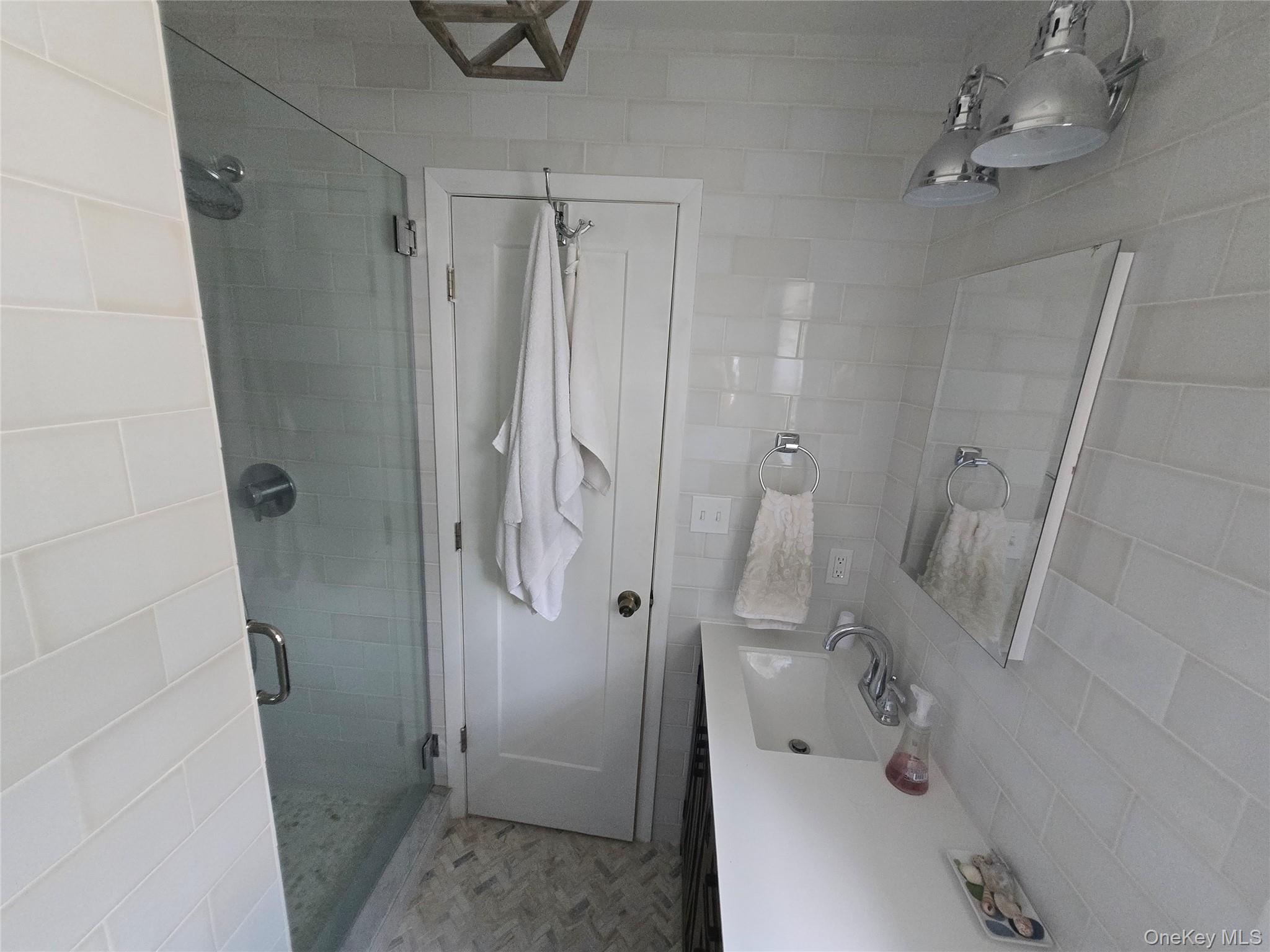870 Noyack Road Southampton, NY 11968 - Photo 13 of 19 a bathroom with a sink and shower