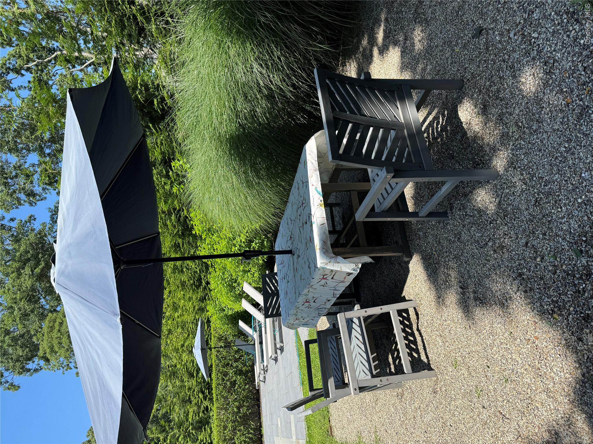 870 Noyack Road Southampton, NY 11968 - Photo 18 of 19 a view of a patio with table and chairs under an umbrella