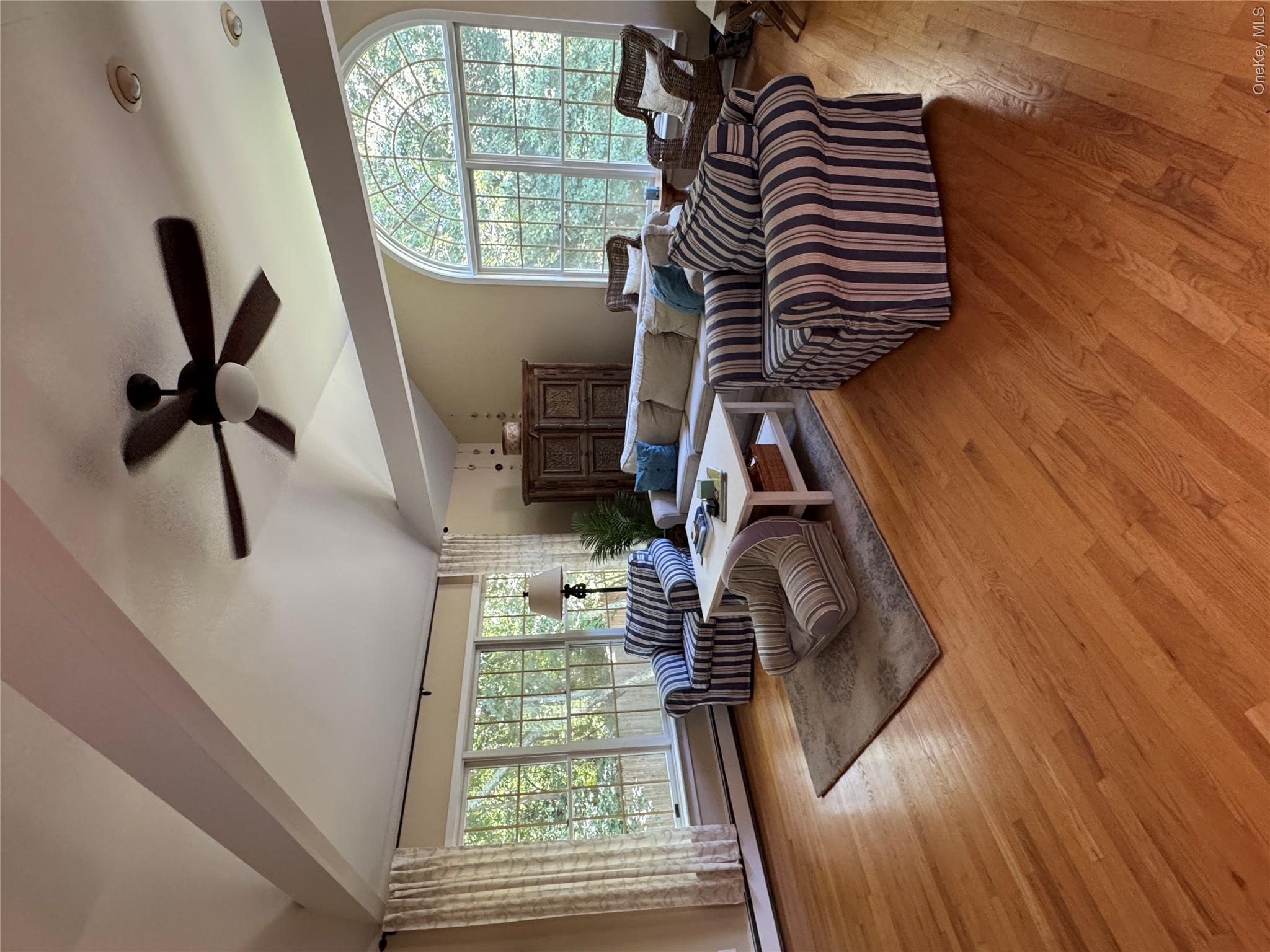 870 Noyack Road Southampton, NY 11968 - Photo 6 of 19 a living room with furniture floor to ceiling window and wooden floor