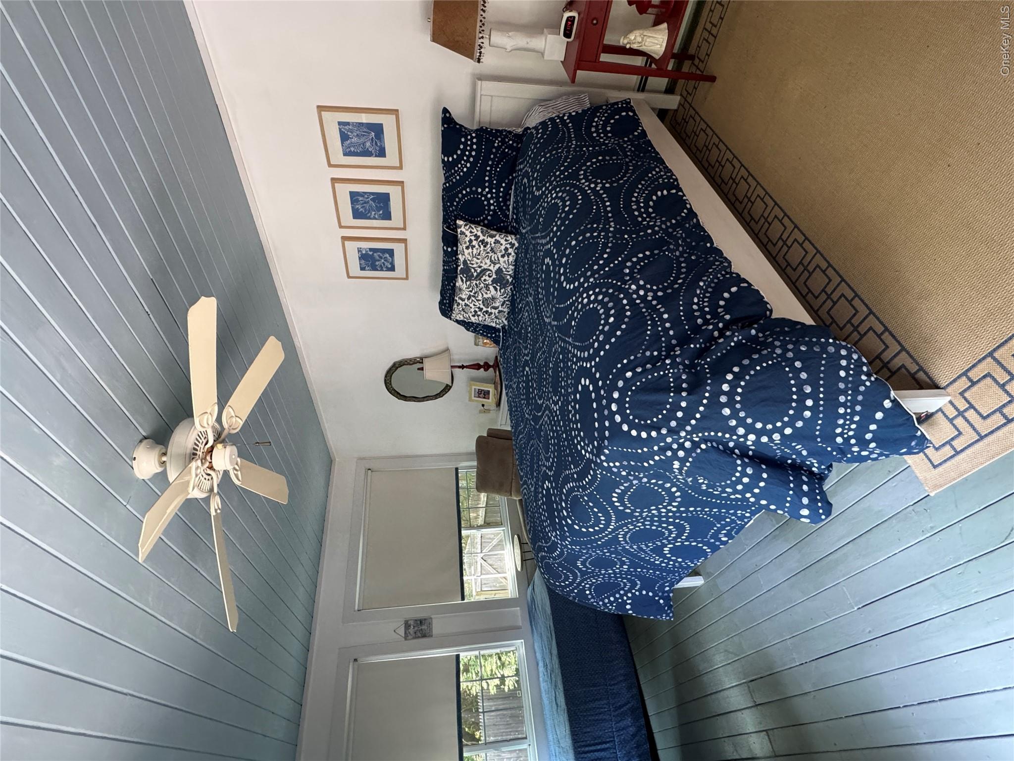 870 Noyack Road Southampton, NY 11968 - Photo 9 of 19 a bedroom with a large bed and a chandelier