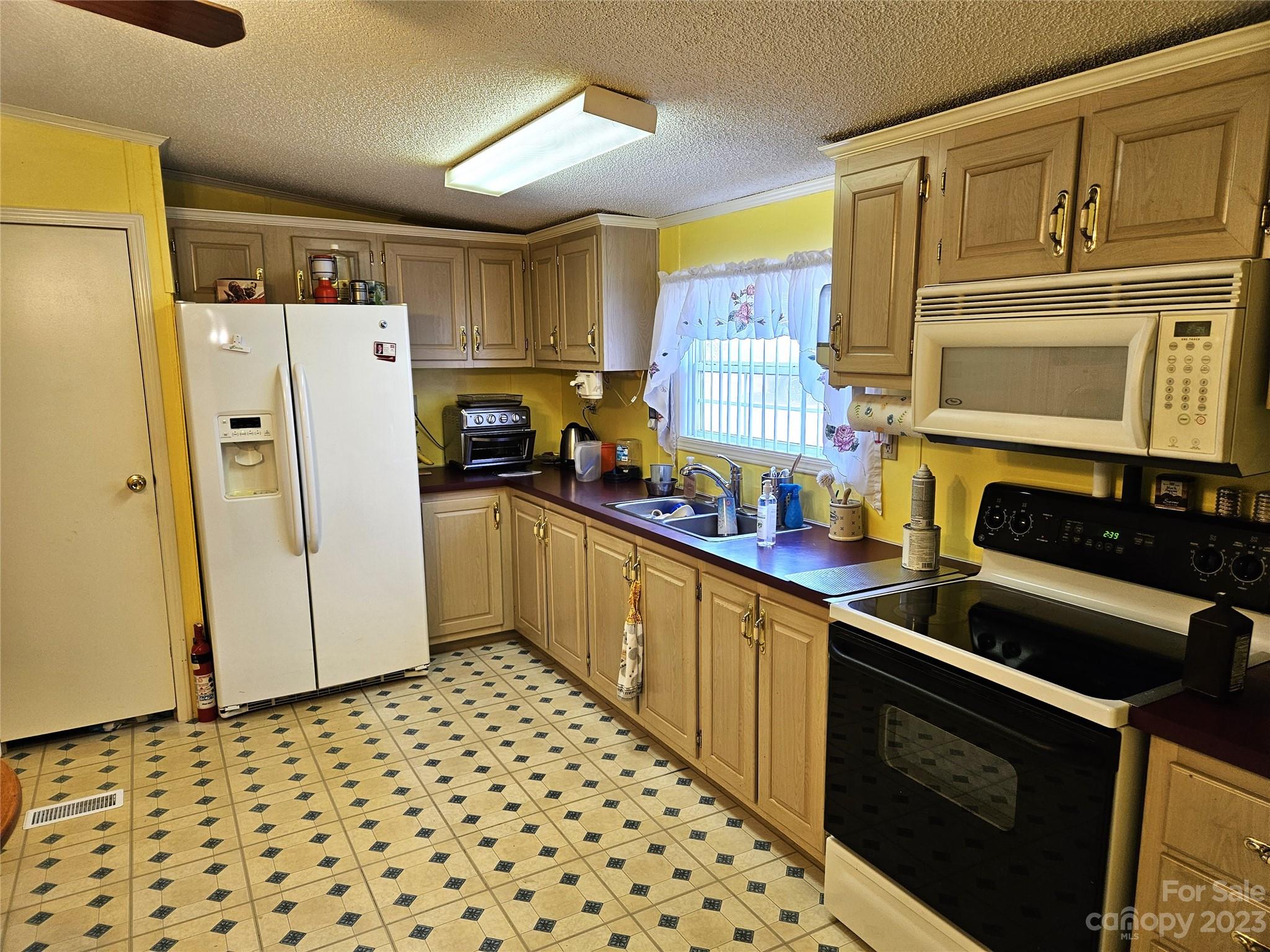 2955 Piney Road Morganton, NC 28655 - Photo 14 of 43 a kitchen with granite countertop a refrigerator a stove a sink dishwasher and wooden cabinets