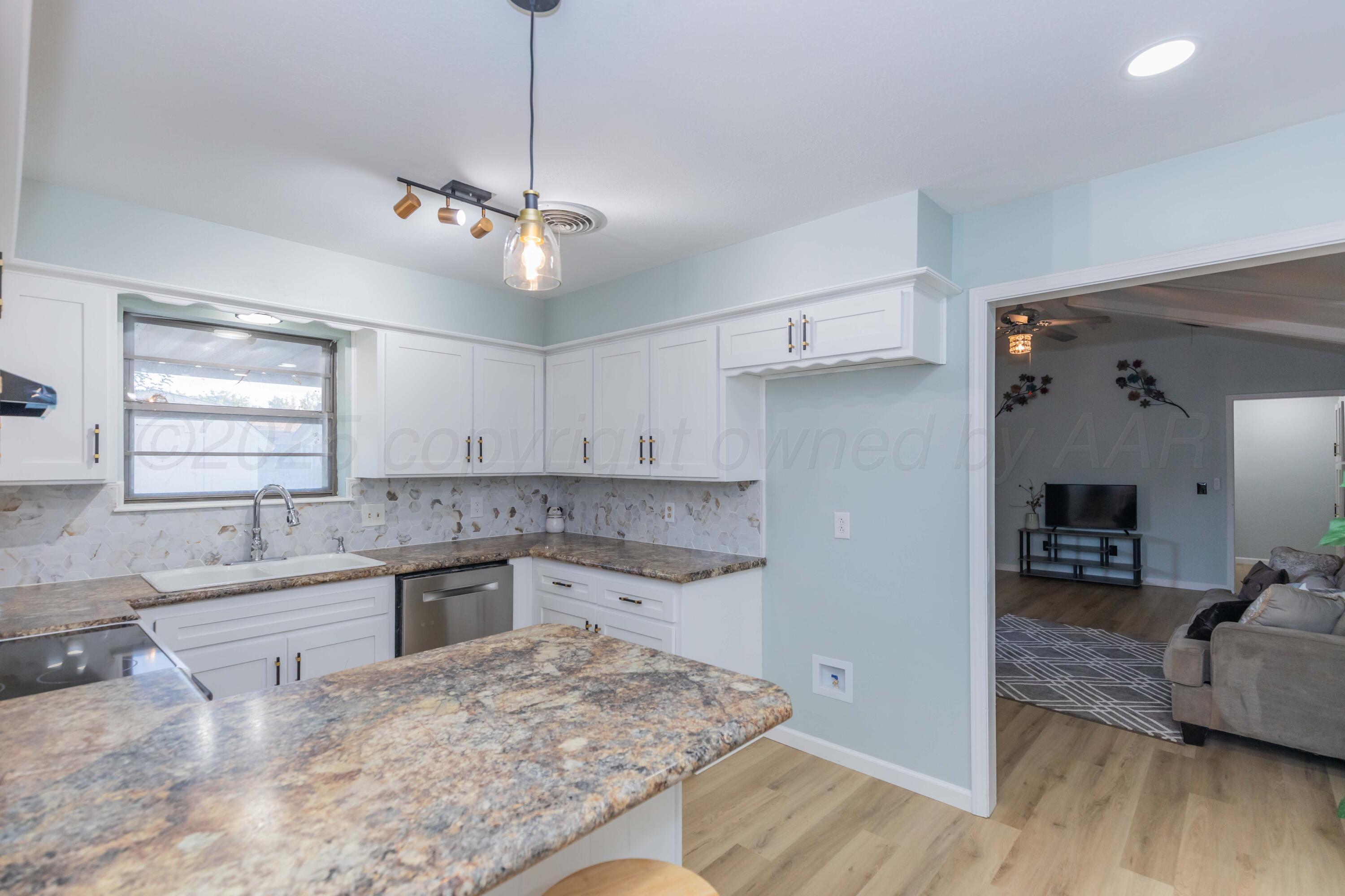 7912 Gerald Drive Amarillo, TX 79121 - Photo 12 of 45 a kitchen with a sink stove and wooden floor