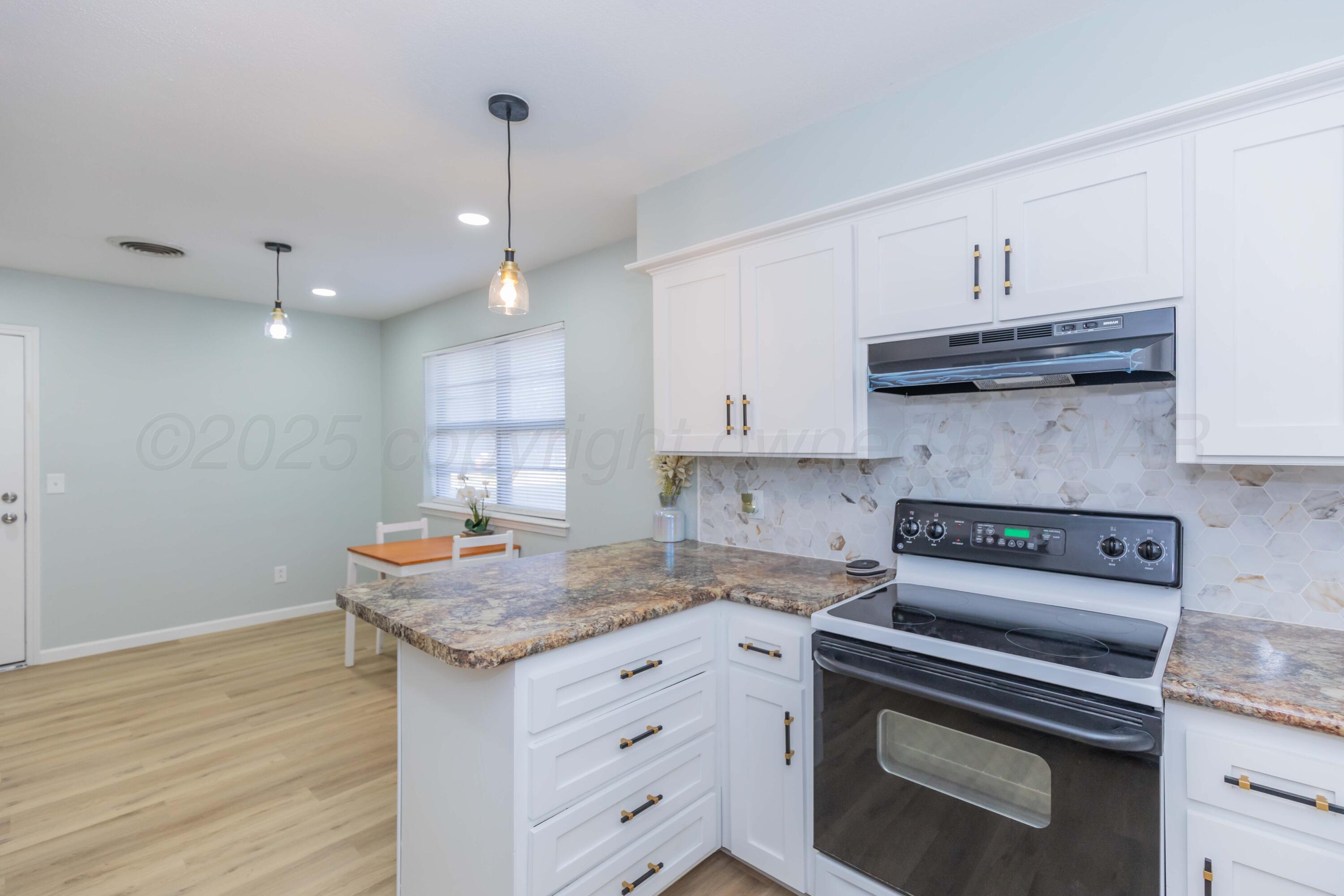 7912 Gerald Drive Amarillo, TX 79121 - Photo 14 of 45 a kitchen with granite countertop a stove and cabinets