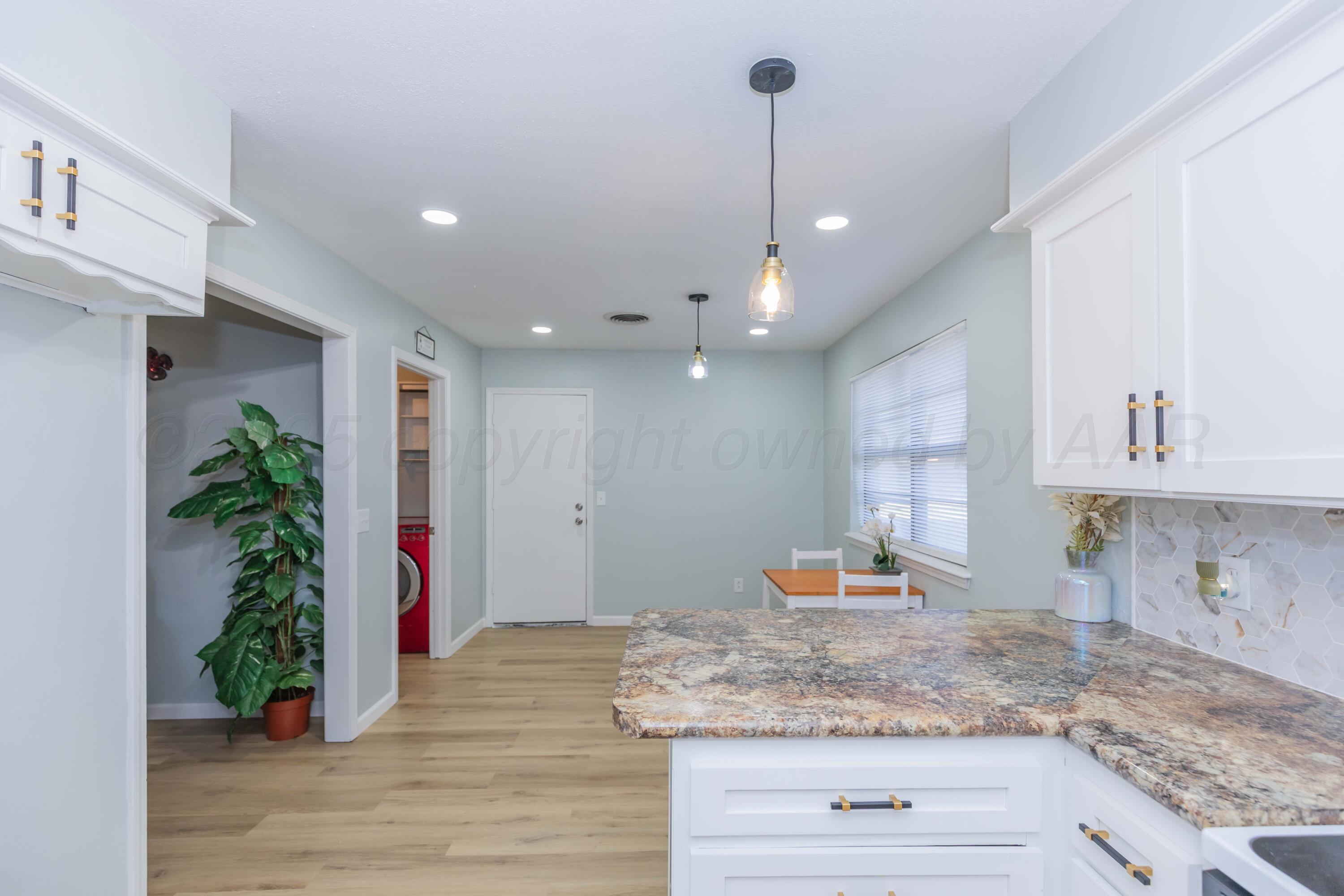 7912 Gerald Drive Amarillo, TX 79121 - Photo 16 of 45 a view of a kitchen with kitchen island a potted plant on the counter