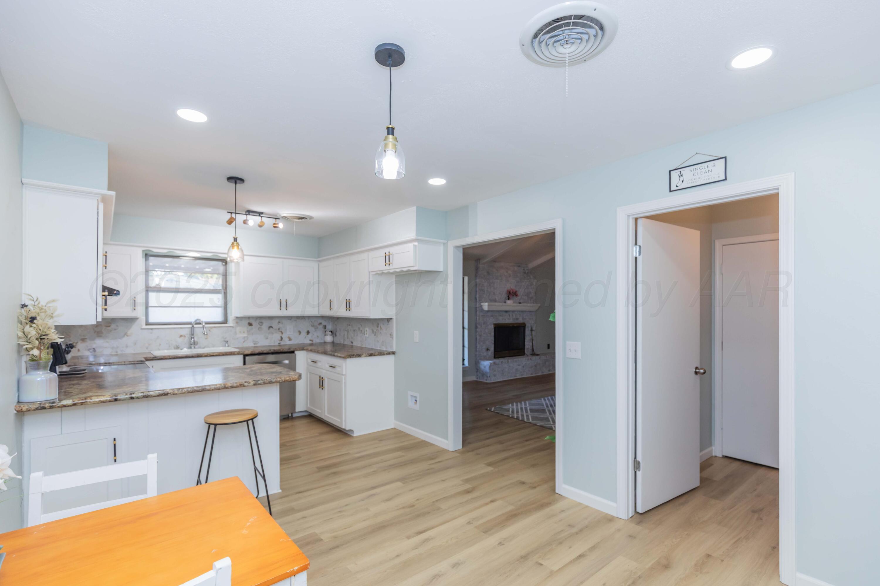 7912 Gerald Drive Amarillo, TX 79121 - Photo 19 of 45 a kitchen with stainless steel appliances granite countertop a sink cabinets and wooden floor