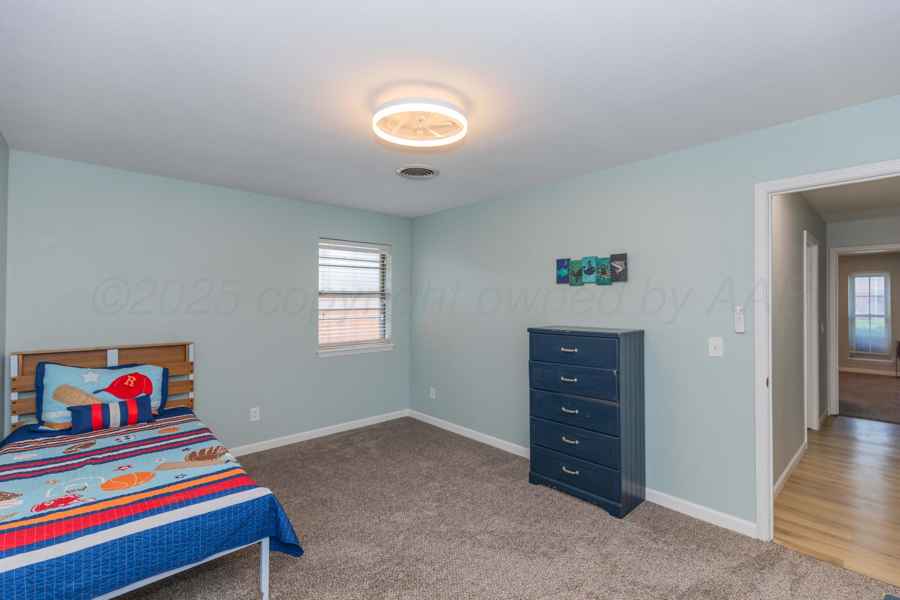 7912 Gerald Drive Amarillo, TX 79121 - Photo 27 of 45 a living room with baby bed and dresser