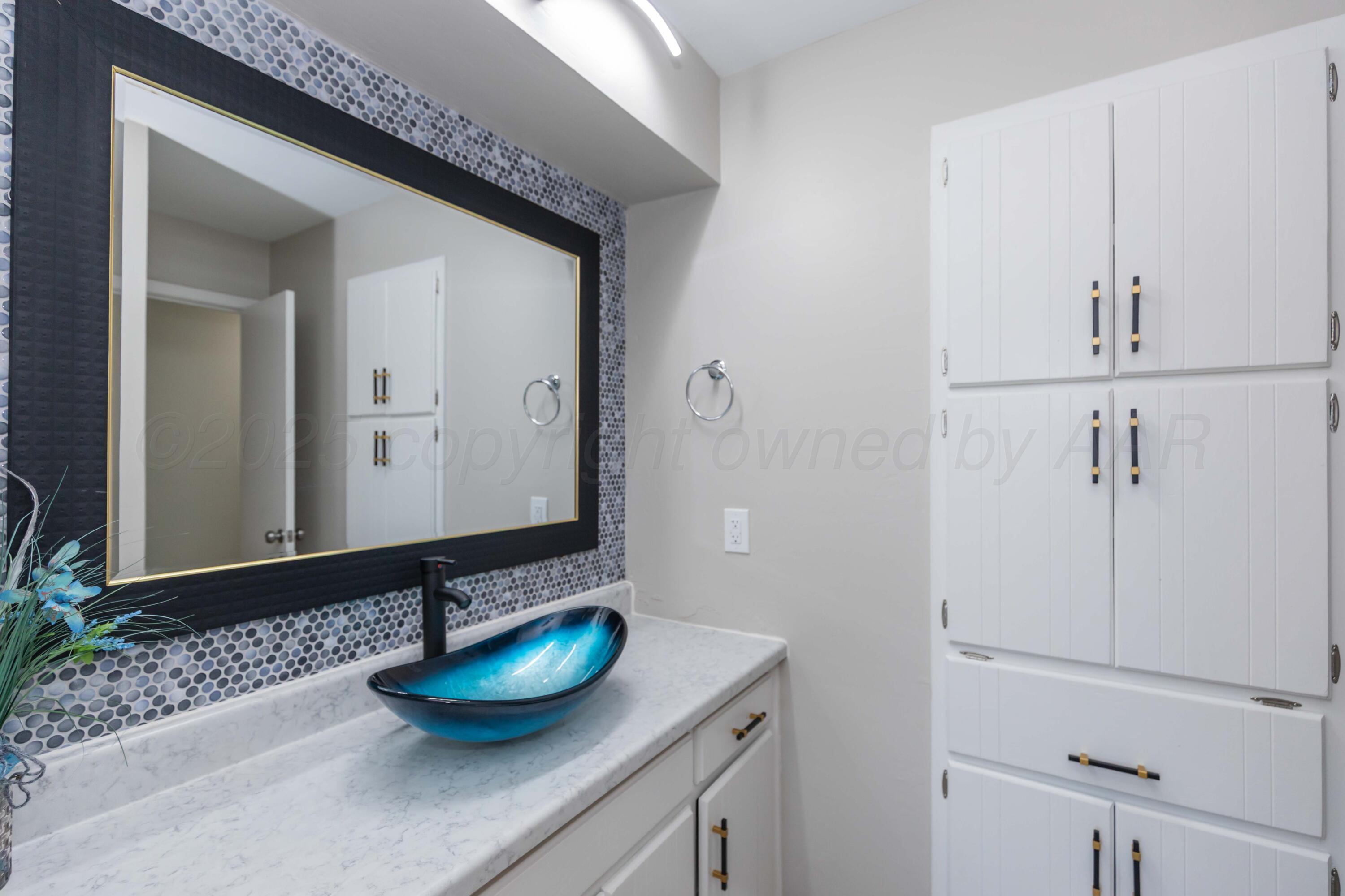 7912 Gerald Drive Amarillo, TX 79121 - Photo 31 of 45 a bathroom with a granite countertop sink and a mirror