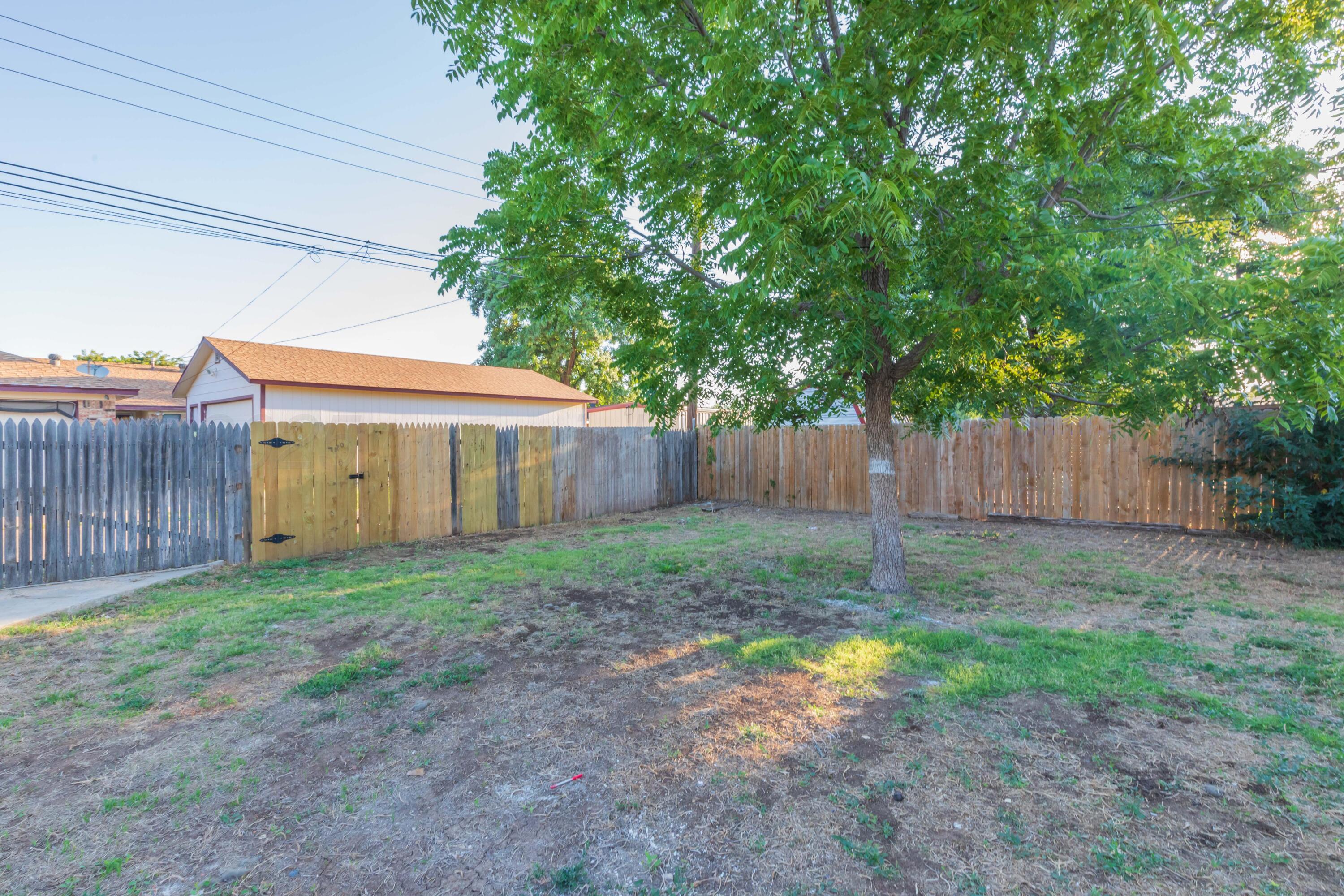 7912 Gerald Drive Amarillo, TX 79121 - Photo 43 of 45 a view of a backyard with large trees and wooden fence