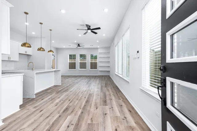 a view of a kitchen with wooden floor and windows
