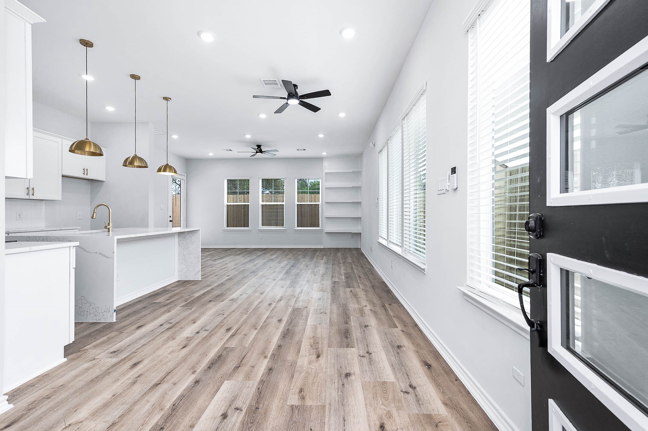 a view of a kitchen with wooden floor and windows