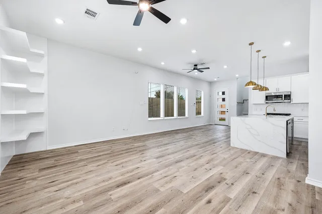 a view of a kitchen with furniture and wooden floor