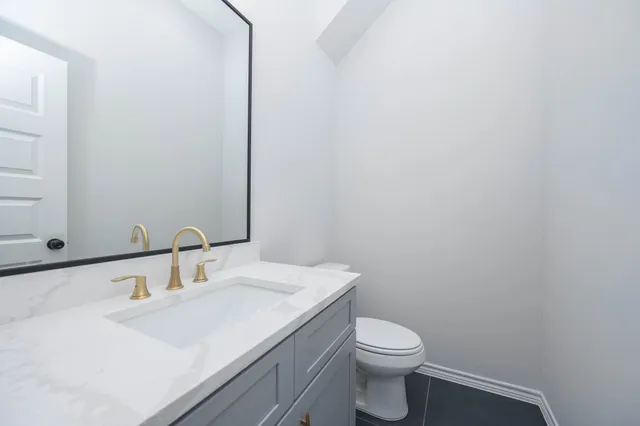 a bathroom with a sink a toilet and mirror