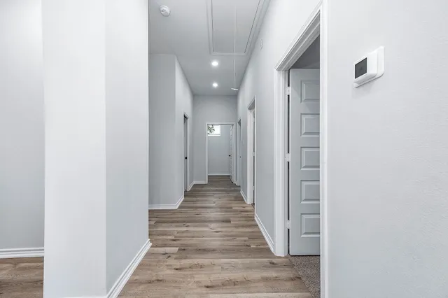 a view of a hallway with wooden floor