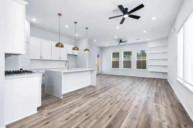 a large kitchen with stainless steel appliances kitchen island a large counter space a sink and a window