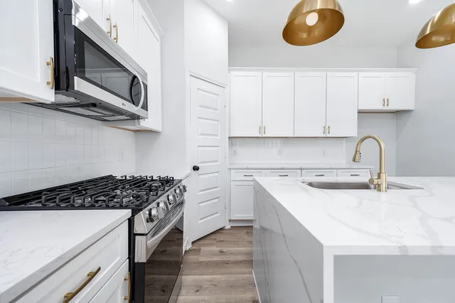 a kitchen with stainless steel appliances a stove a sink and cabinets