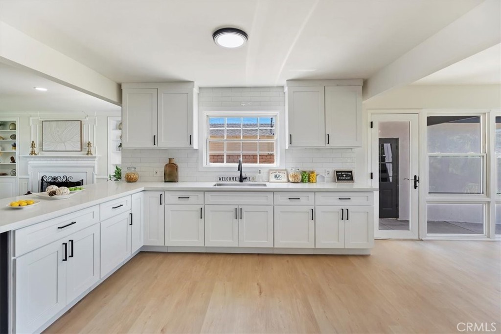 1748 Prince Albert Drive Riverside, CA 92507 - Photo 17 of 42 a large white kitchen with granite countertop white cabinets white appliances a sink and a window