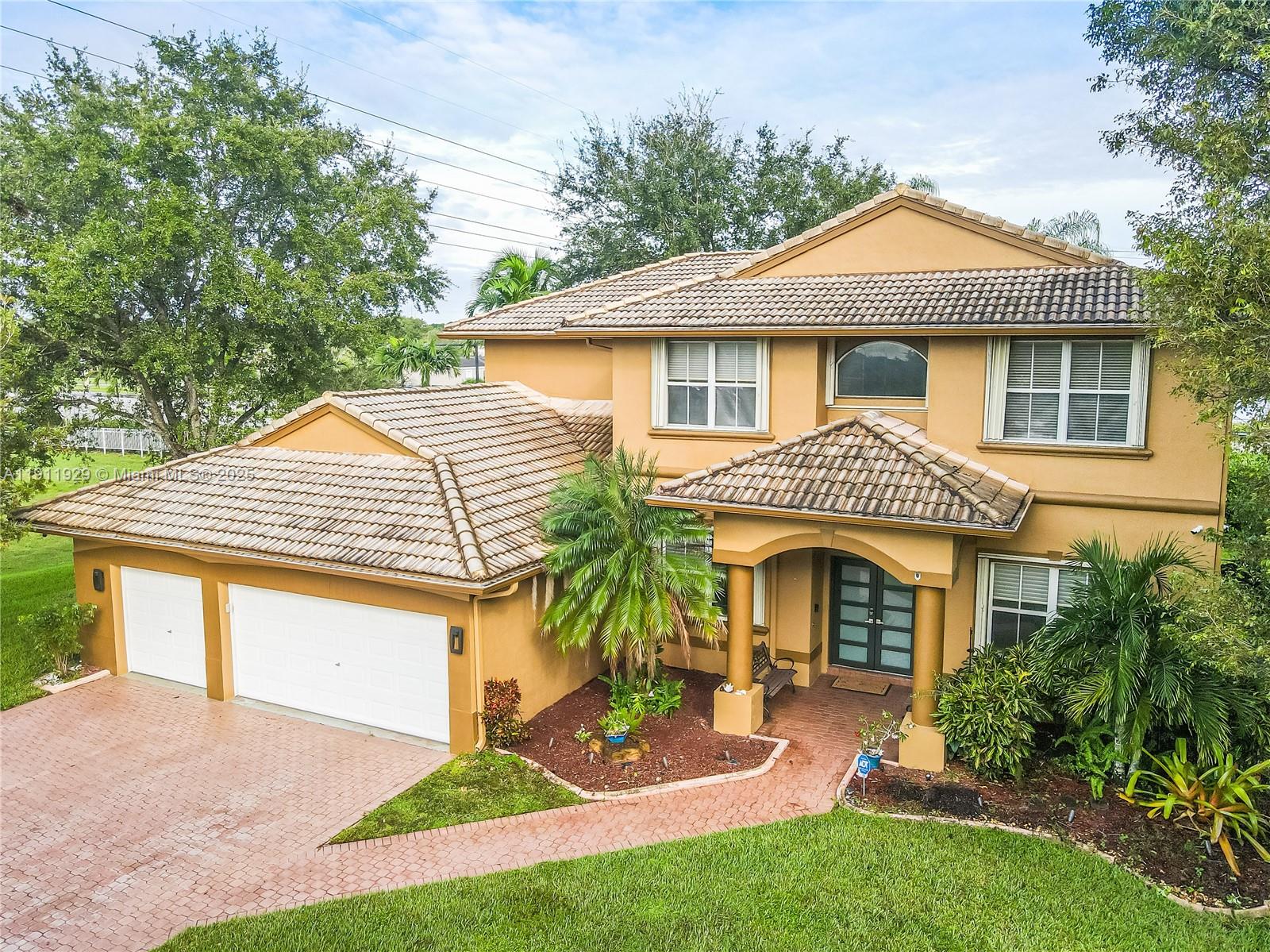 15841 Southwest 61st Street, Unit 15841 Davie, FL 33331 - Photo 2 of 49 a front view of a house with a yard and garage