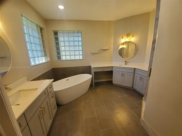 a bathroom with a tub sink and mirror