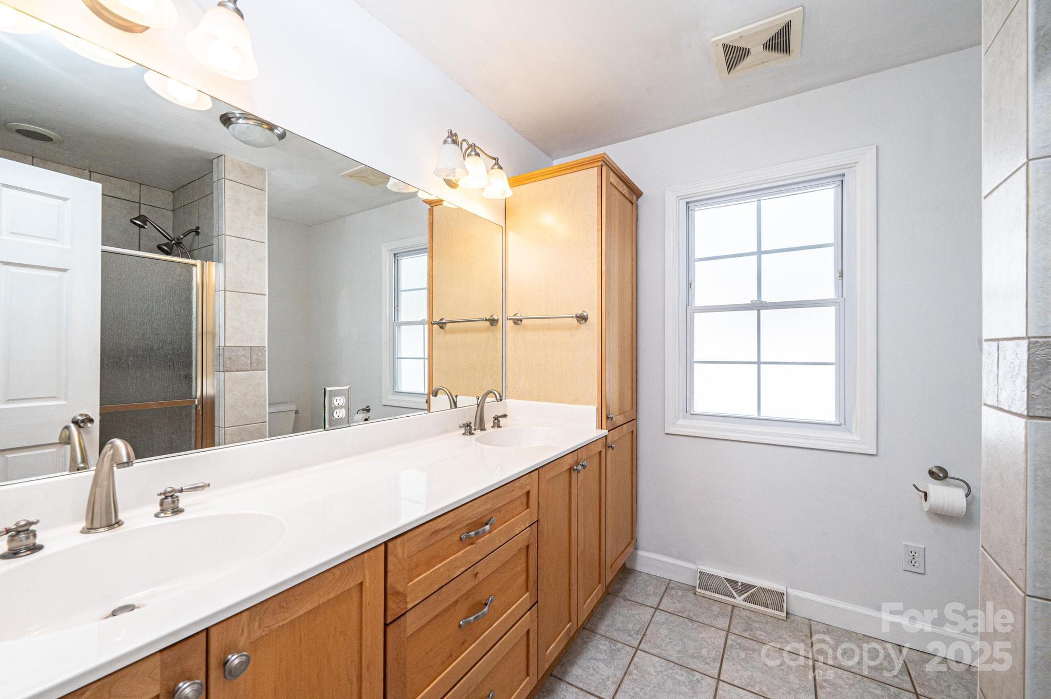 4846 Midway Sand Road Hickory, NC 28601 - Photo 34 of 48 a bathroom with a double vanity sink bathtub and next to a window