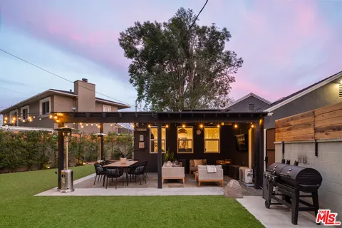 a view of a patio with couches table and chairs and potted plants