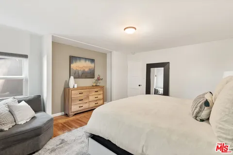 a bedroom with a bed and wooden floor