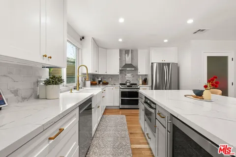 a kitchen with a sink a stove top oven and refrigerator