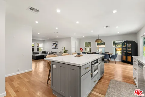 a kitchen with a sink and wooden floor