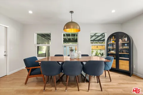 a dining room with furniture window and wooden floor