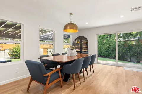 a dining room with furniture a chandelier and wooden floor
