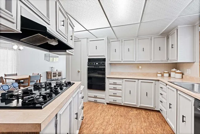 a kitchen with stainless steel appliances a sink a stove and cabinets