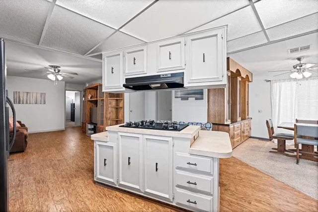 a kitchen with stainless steel appliances a stove a sink dishwasher and a refrigerator with wooden floor