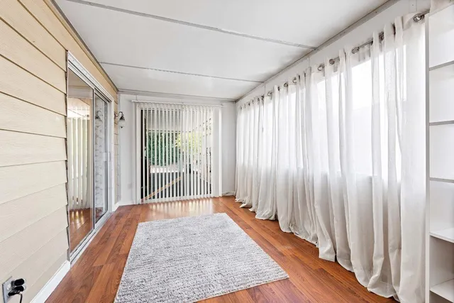 a view of a bedroom with wooden floor and stairs
