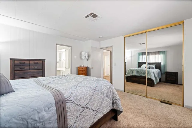 a spacious bedroom with a bed and a dresser