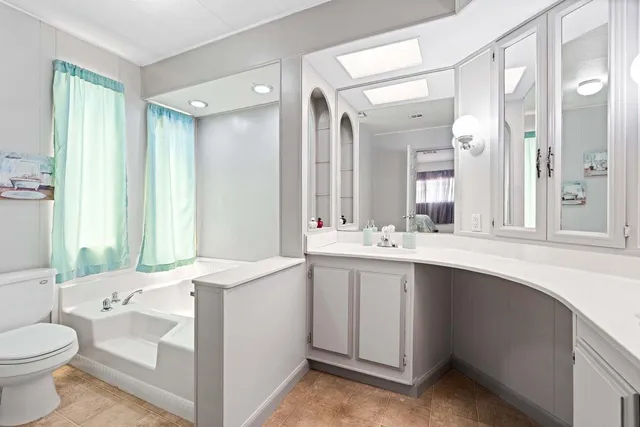 a bathroom with a sink double vanity mirror and toilet