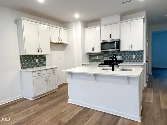 a kitchen with appliances a sink and cabinets